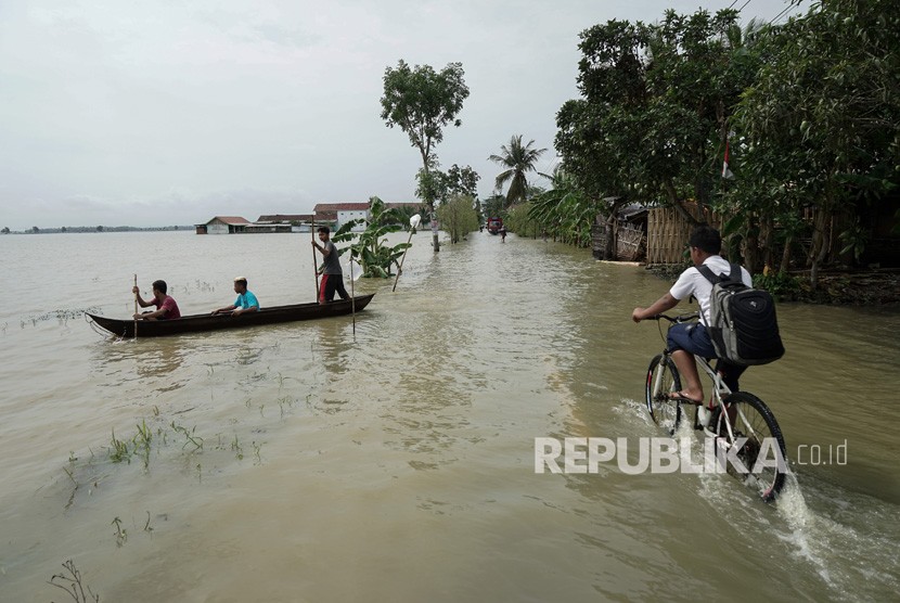 Siswa sekolah melintasi genangan air akibat banjir di Cilacap (ilustrasi)