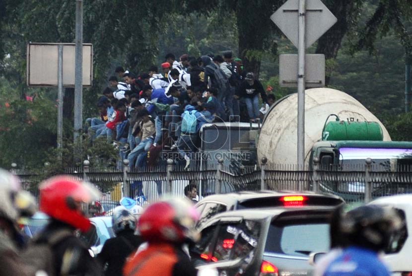  Siswa Sekolah Menengah tingkat atas ditangkap polisi saat menaiki atap bis dalam kota di Jalan Gunung Sahari, Jakarta, Jumat (18/10).     (Republika/ Tahta Aidilla)