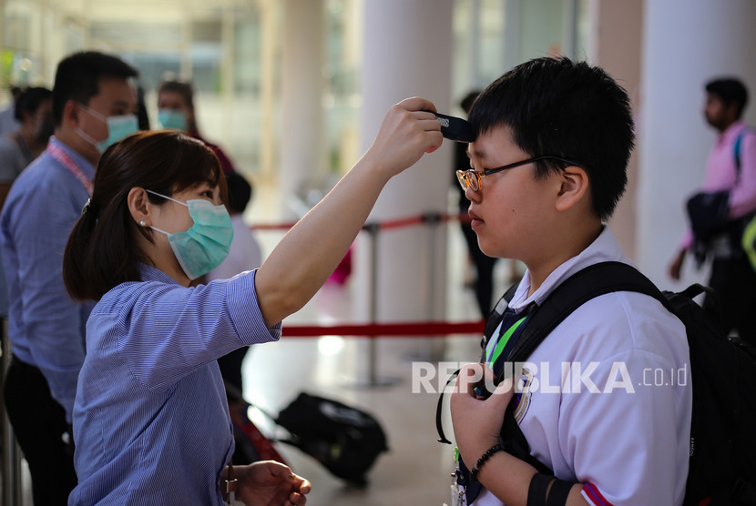 Siswa sekolah menjalani pemeriksaan suhu tubuh sebelum memasuki lingkungan sekolah di Jakarta Nanyang School, Tangerang, Banten, Rabu (4/3/2020). (Antara/Fauzan)