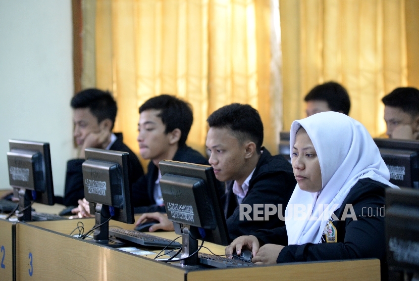  Siswa-siswi mengikuti Ujian Nasional Berbasis Komputer (UNBK) di Sekolah Menengah Kejuruan (SMK) Negeri 32 Jakarta, Senin (3/4).