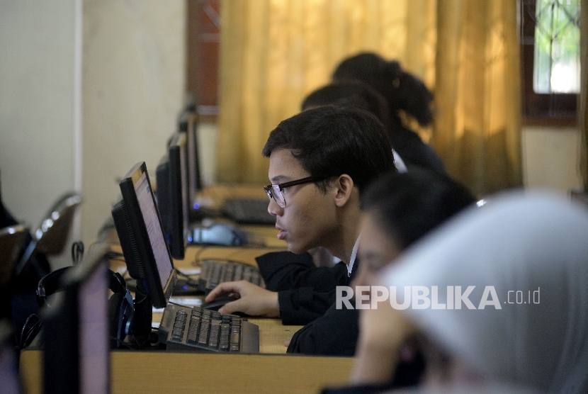 Siswa-siswi mengikuti Ujian Nasional Berbasis Komputer (UNBK) di Sekolah Menengah Kejuruan (SMK) Negeri 32 Jakarta, Senin (3/4).