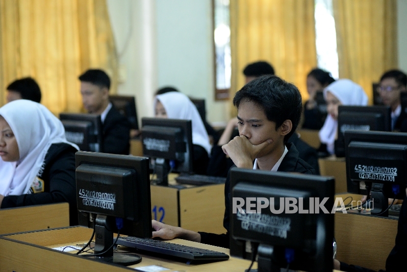 Siswa-siswi mengikuti Ujian Nasional Berbasis Komputer (UNBK) di Sekolah Menengah Kejuruan (SMK) Negeri 32 Jakarta, Senin (3/4)