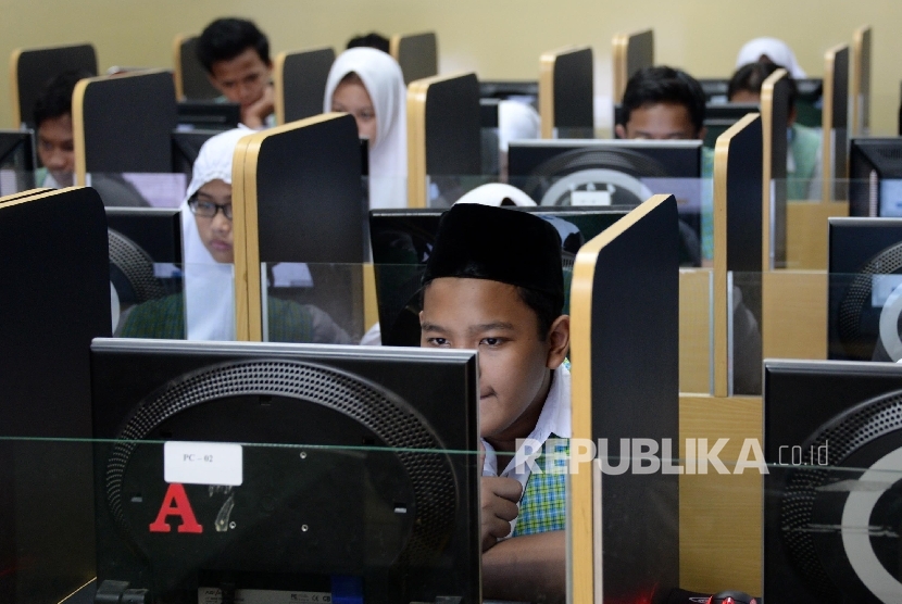 Siswa-siswi MTSN 3 Jakarta, mengerjakan soal ujian mata pelajaran bahasa Indonesia saat Ujian Nasional Berbasis Komputer (UNBK), Senin (9/5). 
