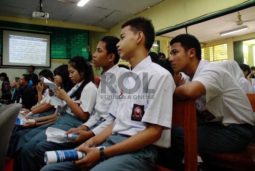 Siswa-siswi SMK 36 Jakarta Pusat mendengarkan Gubernur BI Agus Martowardjojo mengajar di sekolahnya, Selasa (12/8).