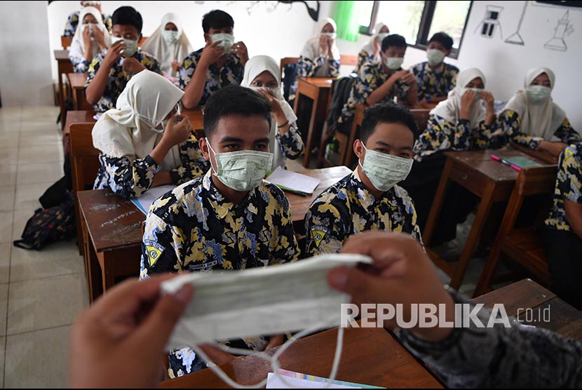 Siswa SMA NU 2 Gresik memakai masker yang dibagikan Lembaga Falakiyah PCNU Gresik. Pembagian masker tersebut bertujuan agar masyarakat mengerti akan kegunaan masker dan mengantisipasi penyebaran virus corona. (ilustrasi)