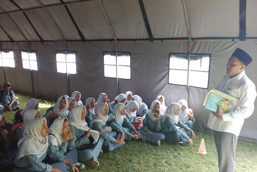 Siswa SMKN 3 Kota Tasikmalaya belajar di tenda, Senin (15/1). Sejumlah ruangan disana mengalami kerusakan lantaran dihantam gempa pada pertengahan Desember lalu.