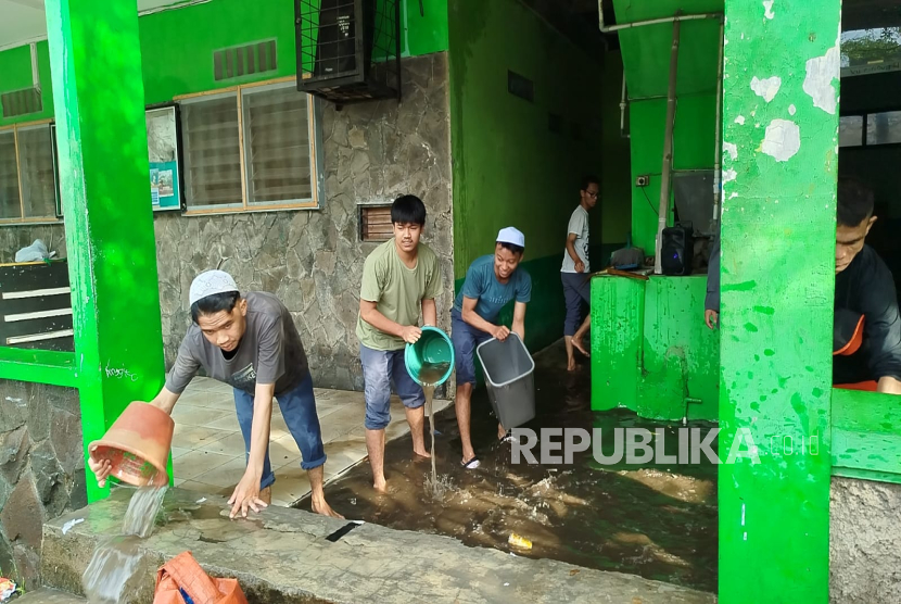 Siswa SMP dan SMK Darussurur, Kota Cimahi Tengah Membersihkan Material Sisa Banjir pada Selasa (29/7/2025).
