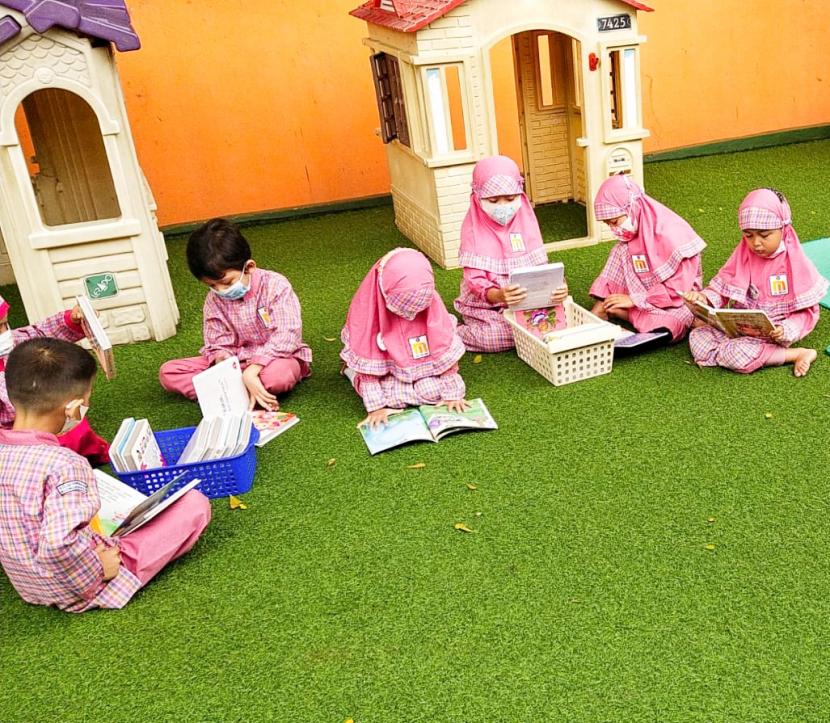 Siswa TK Islam Al-Iman Citayam, Bojonggede, Bogor  sedang membaca buku.