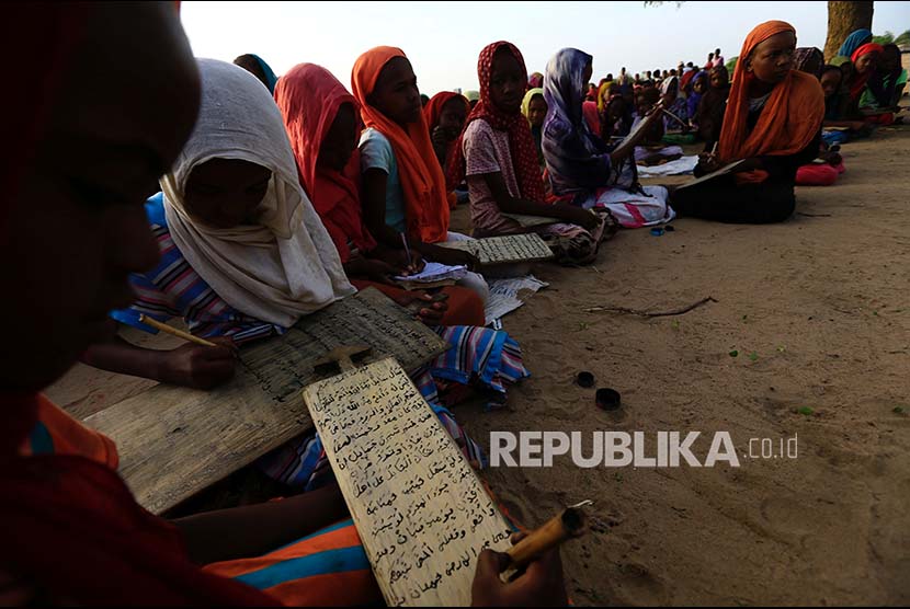Siswi menuliskan ayat Alquran di atas sabak kayu di selatan Kota Darfur, Sudan.