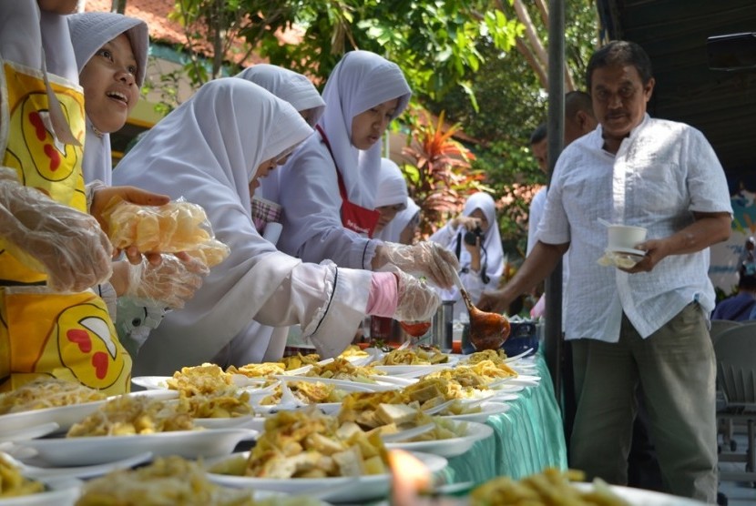 Siswi SMP Putri Luqman al Hakim Hidayatullah Surabaya, Jawa Timur, sedang menyajikan tahu tek.