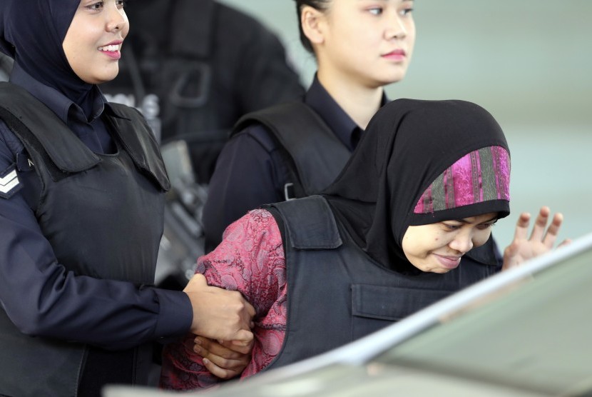  Siti Aisyah (kanan) dikawal polisi saat meninggalkan Pengadilan Tinggi Shah Alam, Malaysia.