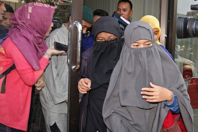 Siti Maesaroh (tengah), istri dari terduga teroris kasus penembakan dan bom di Thamrin, M Ali, berjalan keluar gedung usai masuk ke Pos Ante Mortem RS Polri Kramat Jati, Jakarta, Senin (18/1).