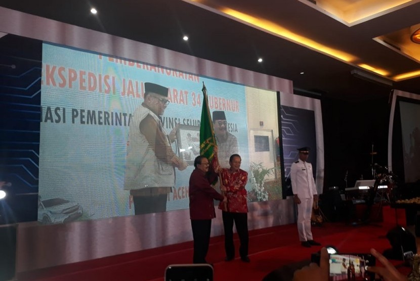 Soekarwo (kiri) Serahkan Jabatan Ketua Asosiasi Pemerintah Provinsi Seluruh Indonesia kepada Gubernur Sulawesi Tengah Longki Djanggola (kanan) ditandai dengan penyerahan bendera APPSI di Ballroom Hotel Grand Inna, Padang, Rabu (20/2).