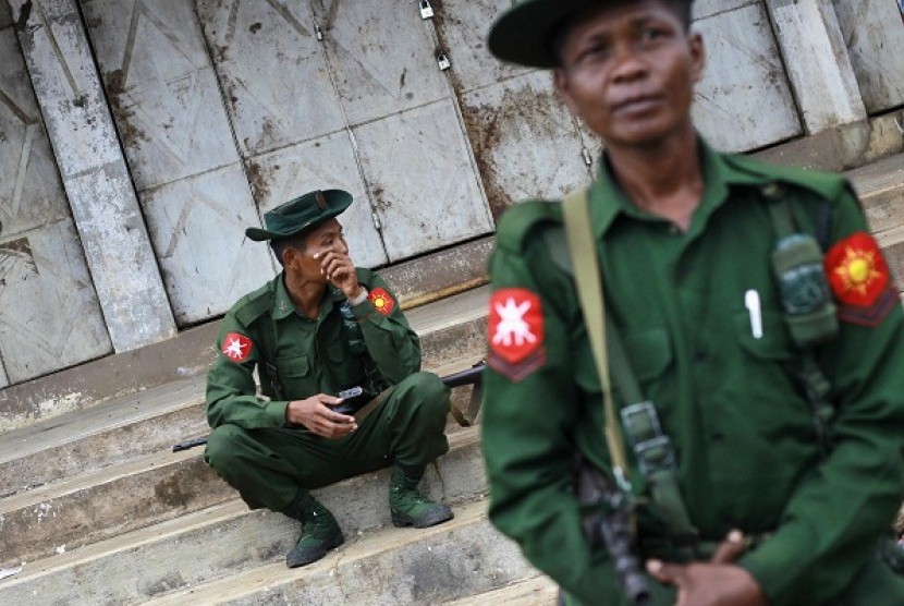 Soldiers pass their time as they guard the city in Lashio township May 30, 2013. 