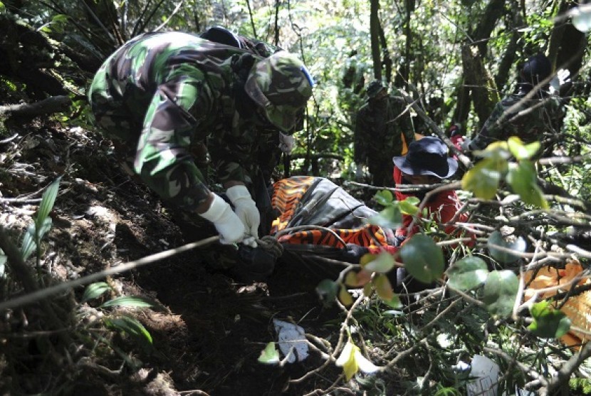 Soldiers remove a body bag containing the remains of victims of the Sukhoi Superjet 100 crash in Mount Salak, West Java.  