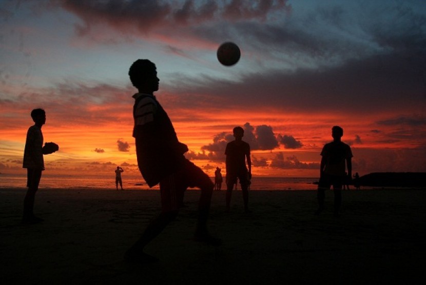 Some kids enjoy playing ball during sunset in Kuta Beach, Bali. Balinese Muslims hold iftar or evening meal for break the fast during sunset in the beach, Sunday. The event draws attention from foreign tourists. (illustration)