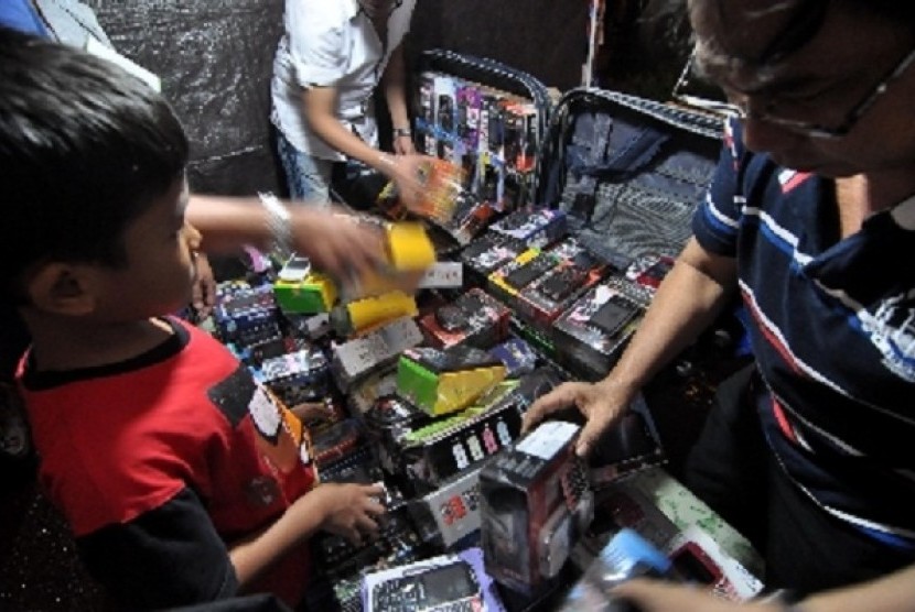 Some potential buyers flock a street vendor sell inexpensive imported cellphones in Jakarta. (illustration)  