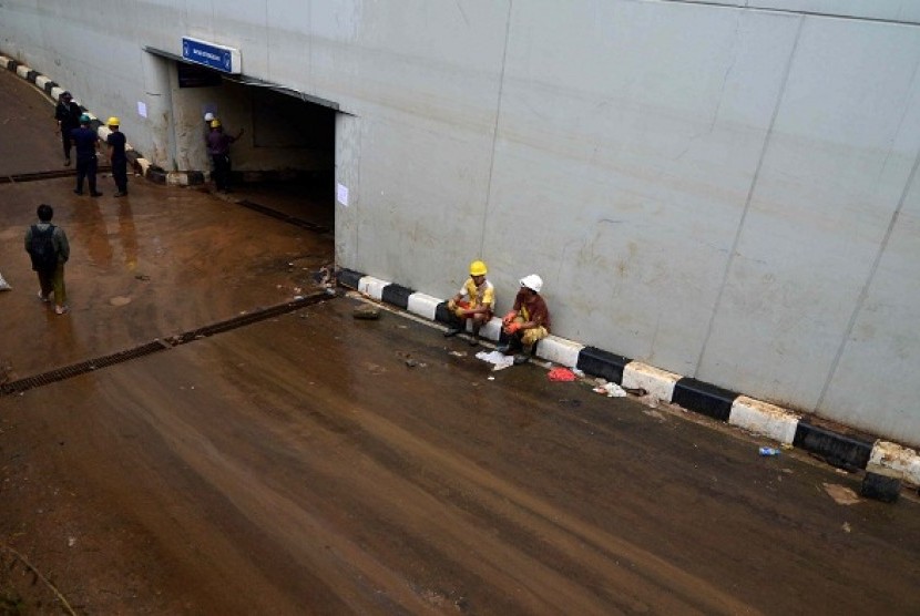 Some rescue team members rest during car evacuation from basement of Plaza UOB in Jakarta on Tuesday. The evacuation process sometimes is hampered by mud and strong smell from the basement.