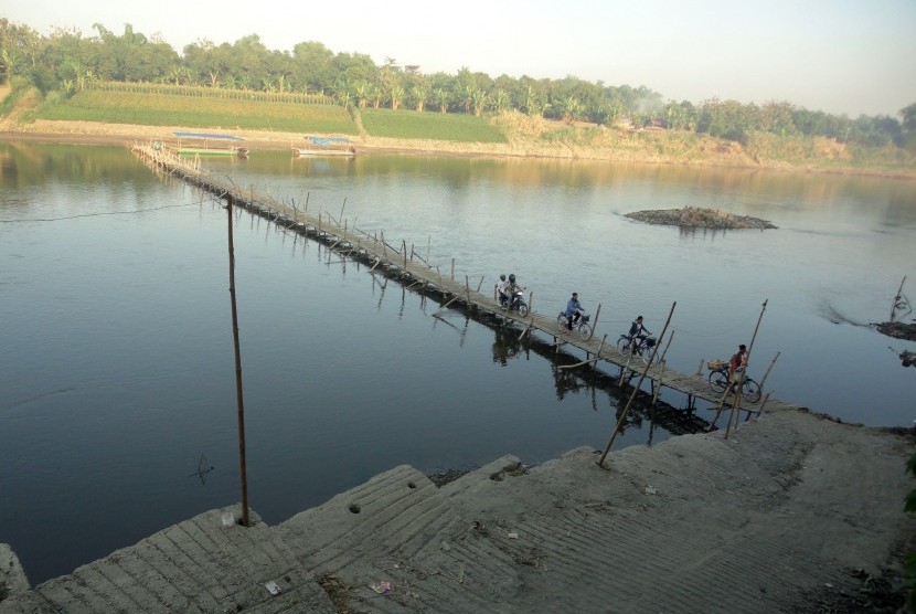 Some residents cross bamboo bridge that connects two villages in Bojonegoro, East Java. Local government plans to build Bengawan Solo Bridge this year. (illustration)
