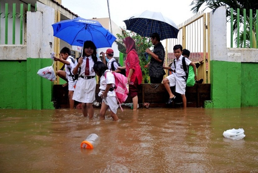 Some school children walk through flooded street to reach their school in Kampung Melayu, East Jakarta, last week. Indonesia is one of flood-prone countries in Southeast Asia. (illustration)