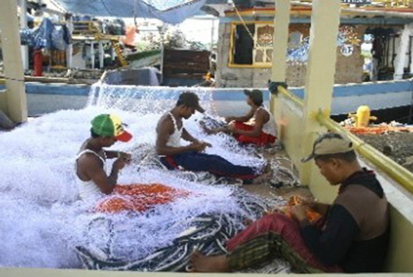 Some traditional fishermen repair fishingnets in Indramayu, West Java. (illustration).  
