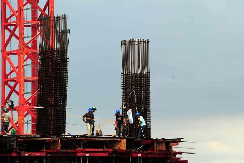 Some workers build a skyscraper in Jakarta. World Bank cut growth projection of Indonesian gross domestic product (GDP) due to moderation of investment growth. (illustration)