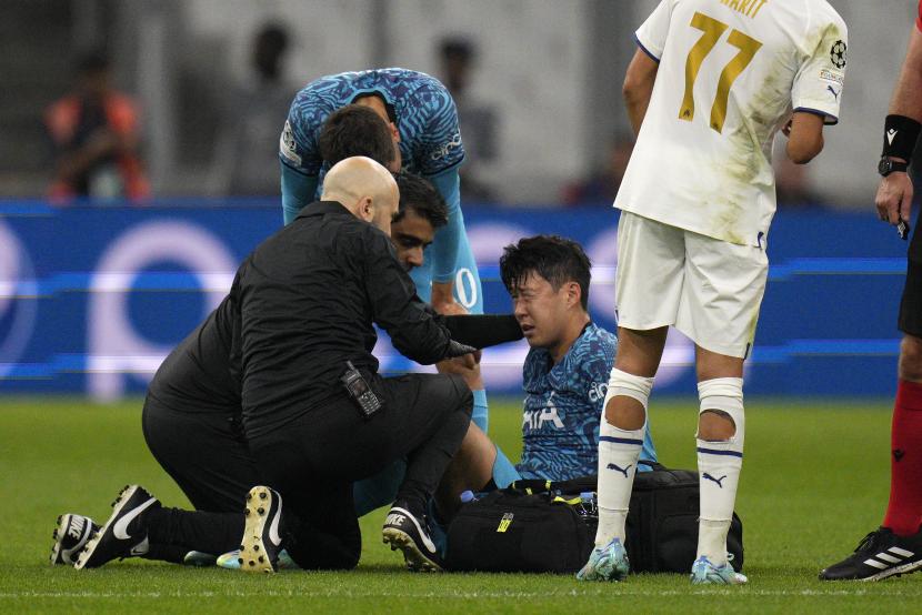 Son Heung-min menerima perawatan setelah mengalami cedera saat pertandingan sepak bola Grup D Liga Champions antara Marseille dan Tottenham Hotspur di Stade Velodrome di Marseille, Prancis, Rabu (2/11/2022) dini hari WIB. Saat pemain cedera, paramedis terkadang menyemprotkan magic spray ke area yang sakit.