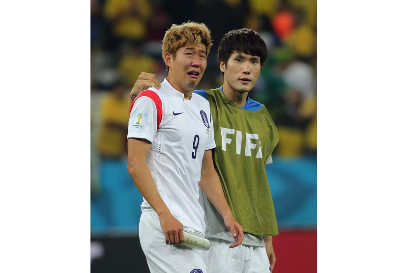 Son Heungmin Korea Selatan (kiri) bereaksi dengan rekan satu tim setelah Piala Dunia FIFA 2014 grup H pertandingan babak penyisihan antara Korea Selatan dan Belgia di Arena Corinthians di Sao Paulo, Brasil, Kamis (26/6).   (Diego Azubel).