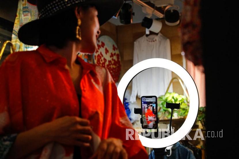 Song Huiyan menunjukkan gaun fashionnya untuk klien daringnya selama live-streaming di toko pakaiannya di Beijing. Pengecer di Cina menggunakan streaming langsung sebagai saluran penjualan di tengah booming 