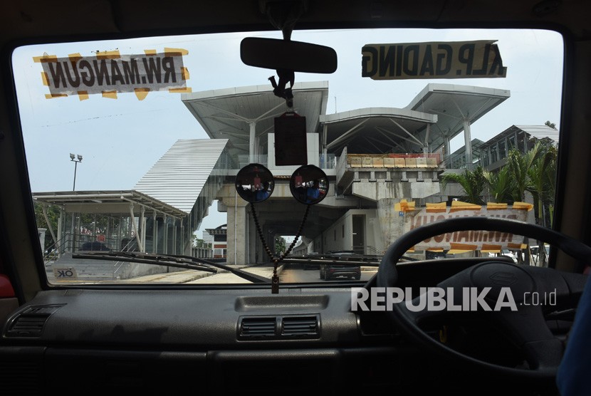 Sopir angkutan kota menunggu penumpang di dekat Stasiun LRT Velodrome yang dalam tahap penyelesaian pembangunan di Rawamangun, Jakarta, Sabtu (16/2/2019). 