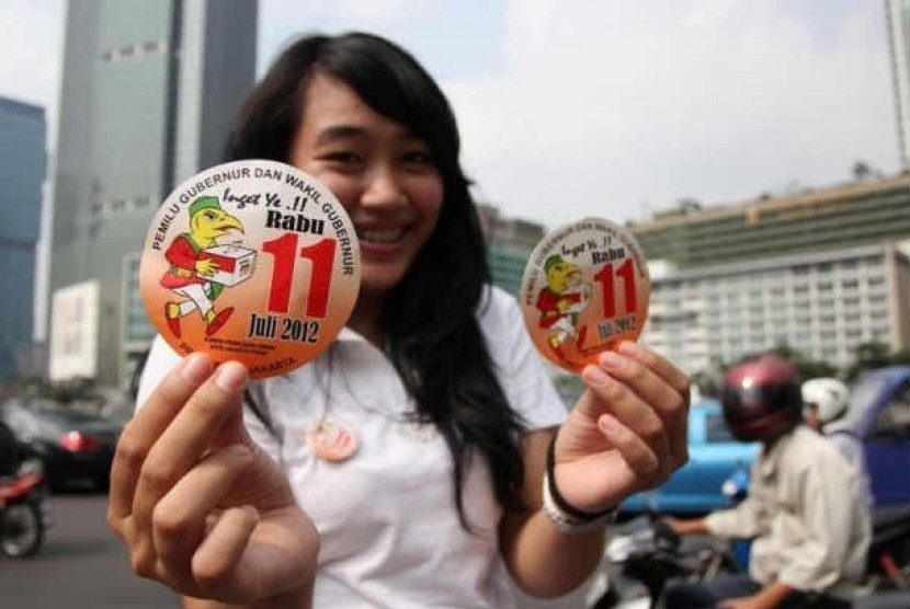 Warga yang tergabung dalam kelompok Bangga Jakarta melakukan aksi damai menggunakan topeng pasangan calon Gubernur DKI Jakarta saat menyampaikan Petisi Pilkada Damai di depan Kantor KPU DKI Jakarta,Jakarta Pusat, Kamis (13/10). 