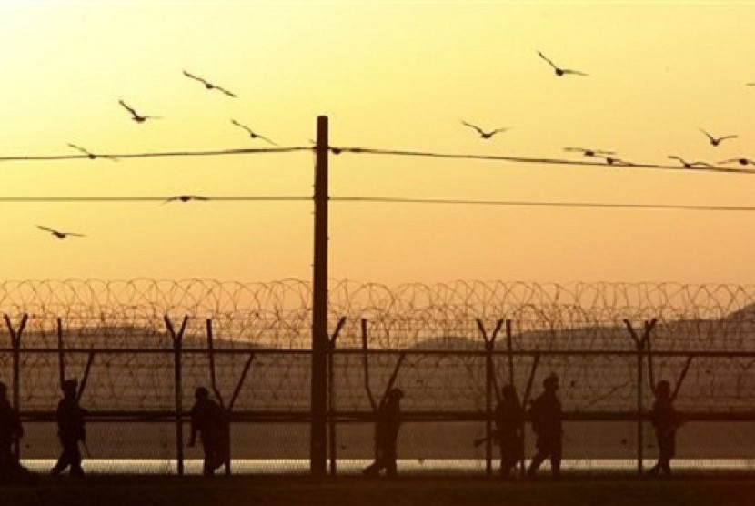 South Korean army soldiers patrol along a barbed-wire fence near the border village of Panmunjom in Paju, South Korea, Tuesday evening, March 26, 2013. 