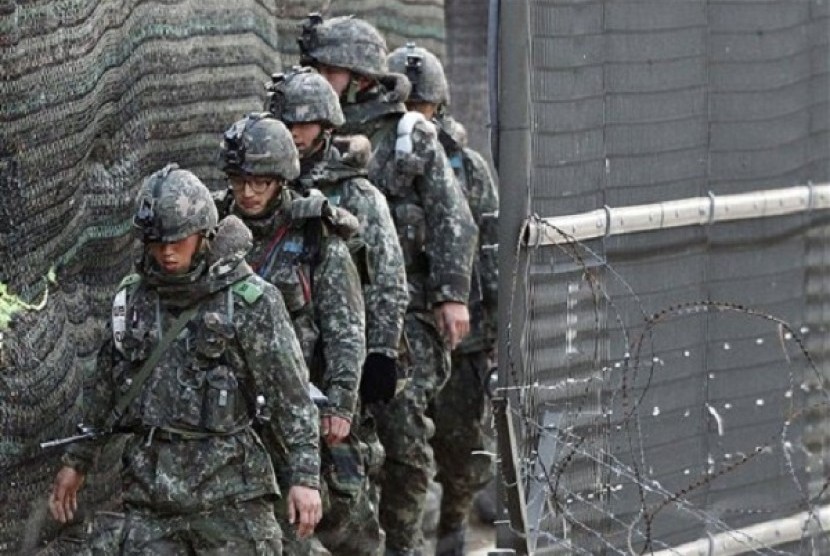 South Korean Army soldiers patrol along a barbed-wire fence near the border village of the Panmunjom, in Paju, South Korea, Saturday, April 13, 2013. 