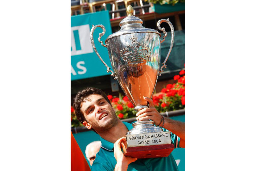 Spain's Pablo Andujar poses with the trophy after defeating Italian Potito Starace 6-1, 6-2 during the final of the Grand Prix Hassan II tennis tournament in Casablanca, Morocco, Sunday, April 10, 2011.