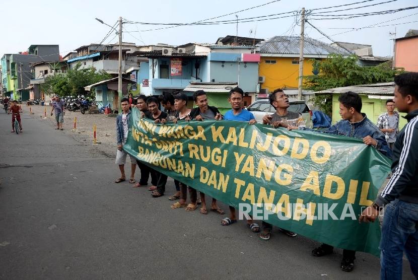 Warga memasang spanduk yang bertuliskan tuntutan ganti rugi atas penertiban permukiman di Kalijodo, Jakarta, Kamis (18/2).