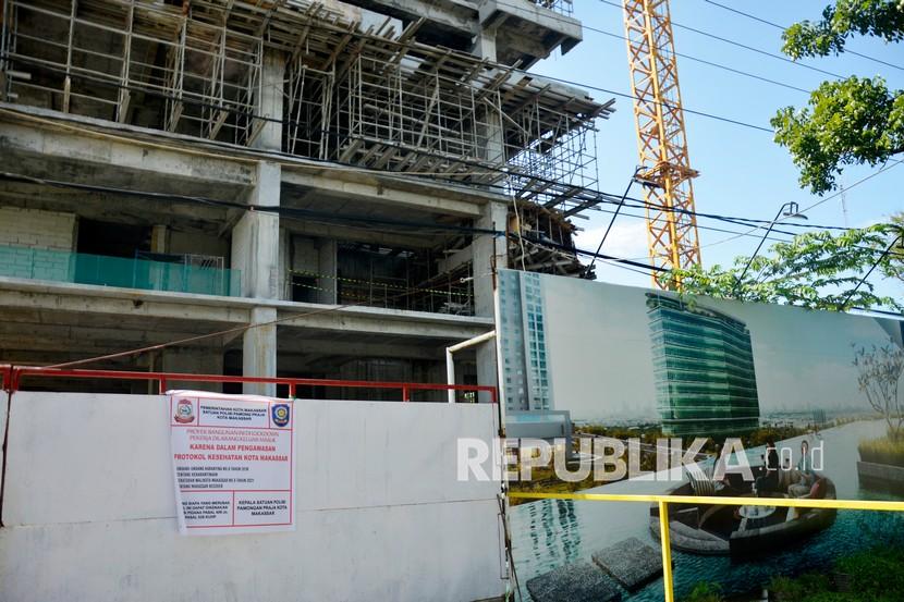 Spanduk pemberitahuan dalam pengawasan terpasang di pintu masuk proyek pembangunan sebuah apartemen di Makassar, Sulawesi Selatan, Sabtu (5/6/2021). Pemerintah Kota Makassar menghentikan sementara aktivitas pembangunan apartemen tersebut menyusul adanya temuan 47 pekerja terkonfirmasi positif COVID-19. A