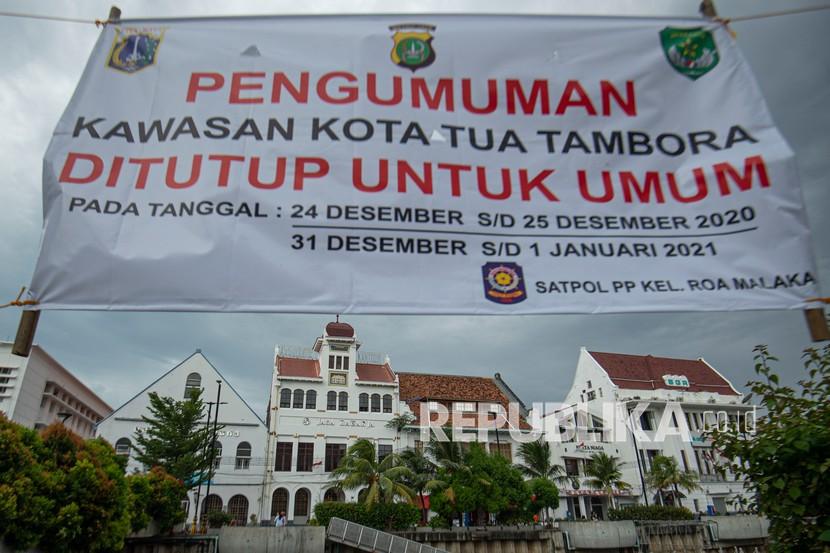 Spanduk pengumuman penutupan kawasan terpasang di depan bangunan-bangunan cagar budaya di Kota Tua, Jakarta, Kamis (24/12/2020). Selain kawasan Kota Tua, Pemerintah Provinsi DKI Jakarta juga menutup area-area publik dan tempat wisata, seperti Ruang Publik Terpadu Ramah Anak (RPTRA), Gelora Bung Karno (GBK), Lapangan Banteng, Taman Impian Jaya Ancol, dan sejumlah tempat lainnya pada masa libur Natal 2020 dan Tahun Baru 2021 untuk mengantisipasi kerumunan yang bisa menjadi klaster penularan COVID-19.