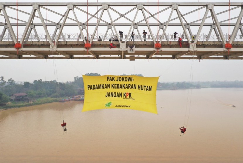 Spanduk raksasa dibentangkan aktivis Greenpeace Indonesia di Jembatan Sungai Kahayan, Palangkaraya, Ahad (22/9).