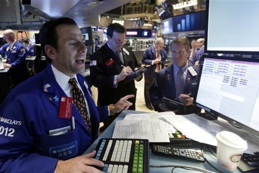 Specialist Michael Pistillo, left, works with traders at his post on the floor of the New York Stock Exchange, Friday, Oct. 31, 2014. 