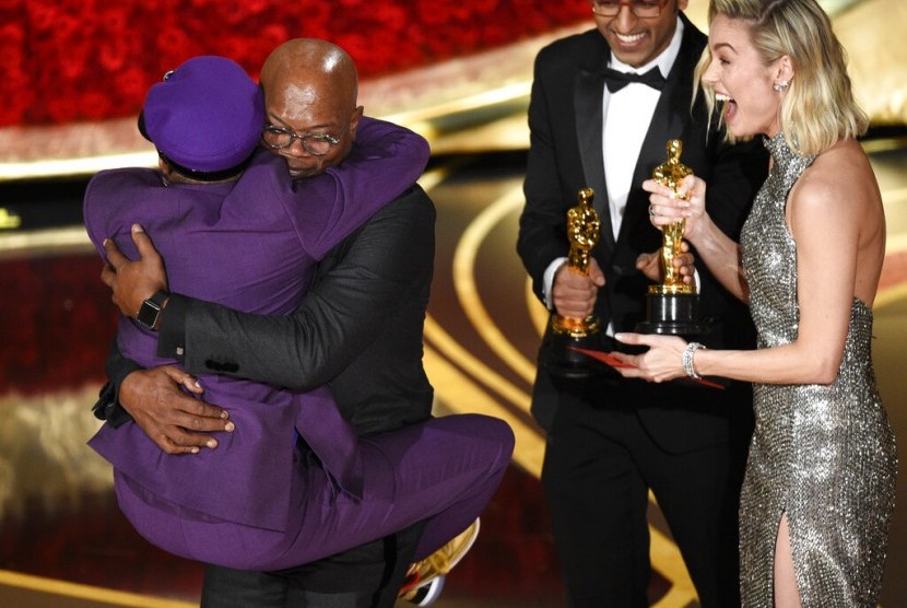 Spike Lee (berbaju ungu) memeluk aktor Samuel L Jackson setelah memenangkan Oscar, Senin (25/2), di Dolby Theatre, Los Angeles.
