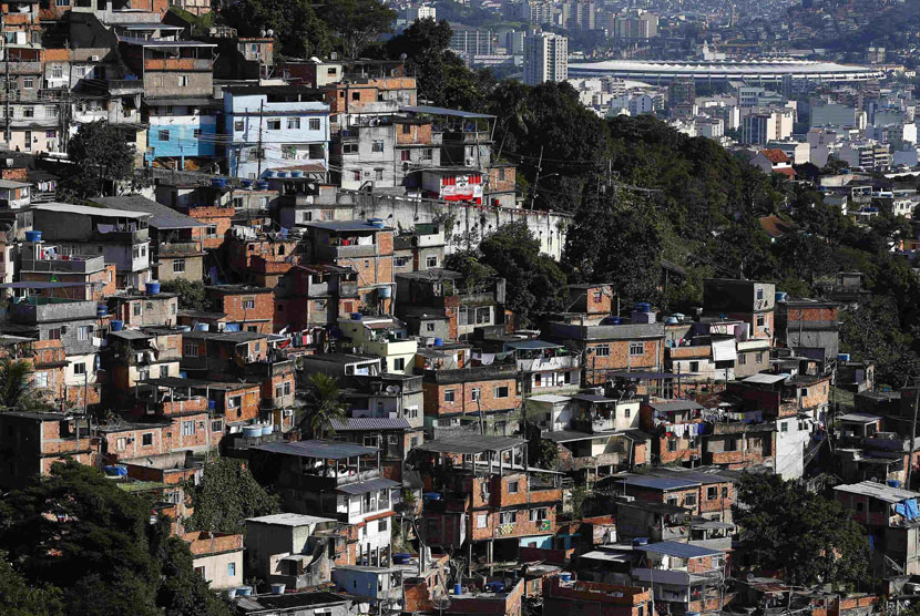 Stadion Maracana terlihat di belakang Favela di Rio de Janeiro, Brasil, Ahad (8/6). 