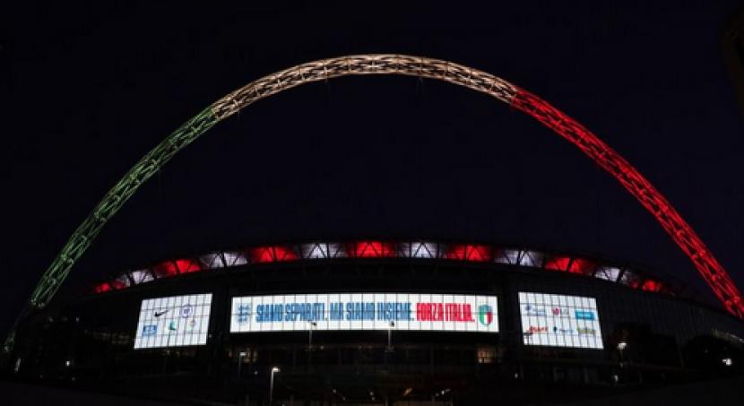 Stadion Wembley menyalakan lampu di lengkung stadionnya dengan warna bendera Italia sebagai bentuk solidaritas dalam perang melawan Covid-19.