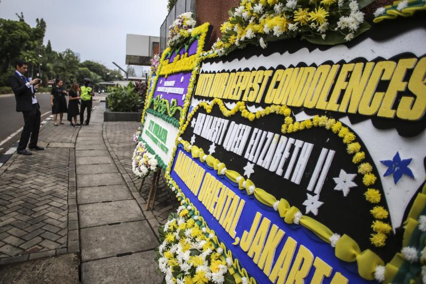 Staf kedutaan memotret karangan bunga bela sungkawa atas wafatnya Ratu Elizabeth II di Kedutaan Besar Inggris, Jakarta, Jumat (9/9/2022). Ratu Elizabeth II wafat pada 8 September 2022 di usia 96 tahun.