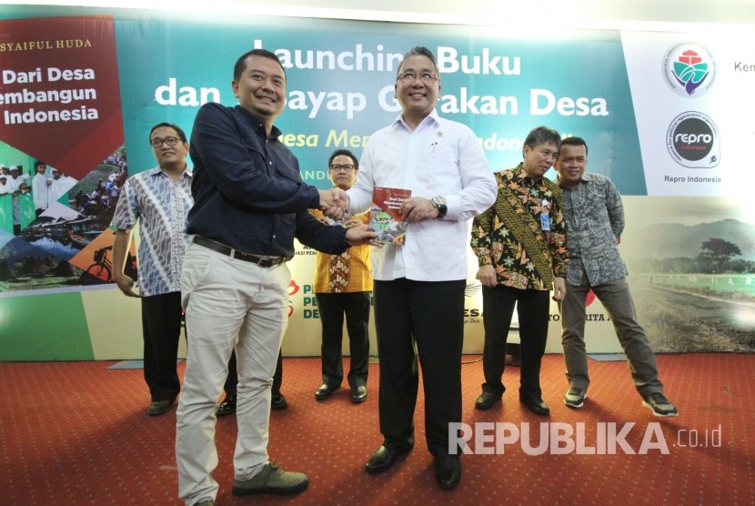 Staf Khusus Menteri Desa dan pembangunan Daerah Tertinggal (PTD) Syaiful Huda (kiri) menyerahkan buku berjudul Dari Desa Membangun Indonesia kepada Menteri PTD Eko Putro Sandjojo saat dilaunching di Kampus UPI, Kota Bandung, Senin (20/11).