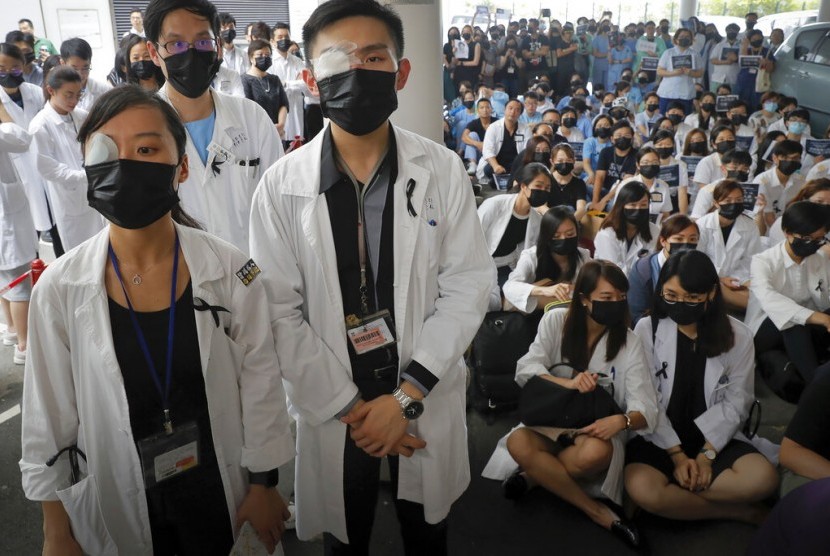 Staf medis menggunakan perban di mata dan masker dalam protes menentang kebrutalan polisi di sebuah rumah sakit di Hong Kong, Selasa (13/8).