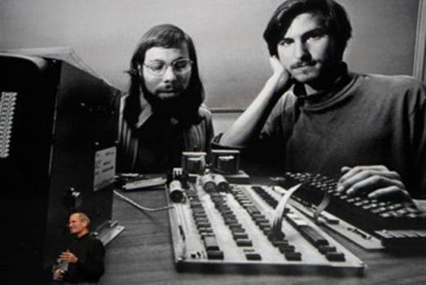 Steve Jobs berdiri membelakangi fotonya bersama dengan salah satu pendiri Apple Steve Wozniak.