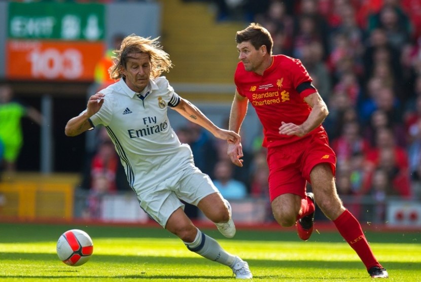 Steven Gerrard (kanan) dijaga Michel Salgado dalam laga amal Legenda Liverpool vs Legenda Real Madrid di Anfield, Sabtu (25/3).