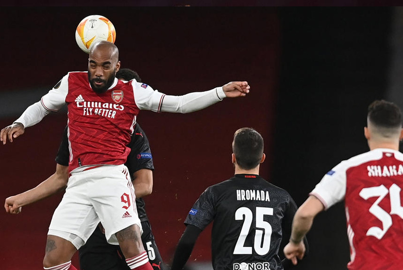Stiker Arsenal Alexandre Lacazette berebut bola di udara dengan pemain Slavia Praha Alexander Bah (back) pada leg pertama perempat final Liga Eropa di London, Jumat (9/4) dini hari WIB.