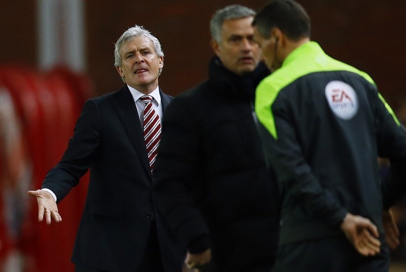 Stoke City manager Mark Hughes (L) reacts as Chelsea manager Jose Mourinho (C) speaks to the fourth official after a tackle from Stoke City's Phillip Bardsley on Chelsea's Eden Hazard during their English Premier League soccer match at the Britannia Stadiu