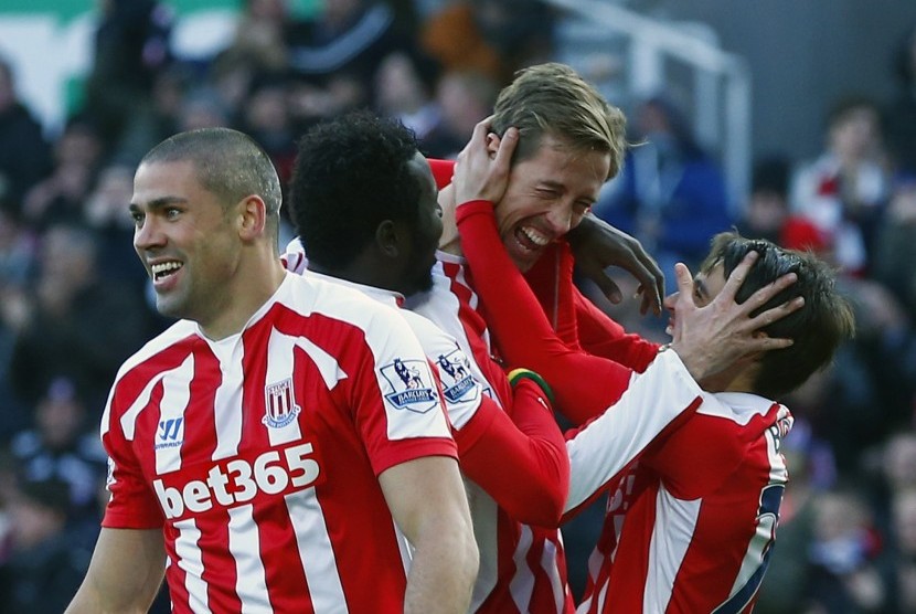 Stoke City's Peter Crouch (C) celebrates his goal against Arsenal with Bojan (R) and Jonathan Walters (L) during their English Premier League soccer match in Stoke, northern England December 6, 2014